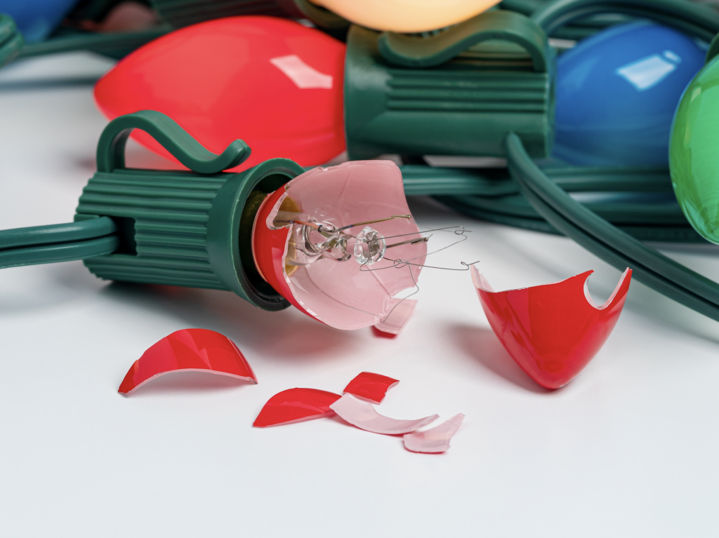 Close-up of red, green and clear Christmas bulbs with green sockets and wiring