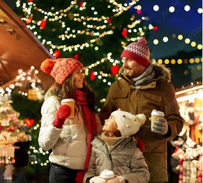 A family sitting beside a decorated Christmas tree